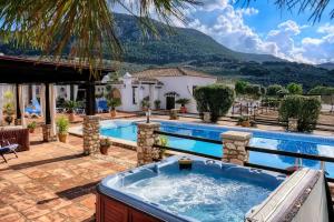 einen Hinterhof mit einem Whirlpool und einem Haus in der Unterkunft Alter Real, luxury holiday retreat in Villanueva del Trabuco