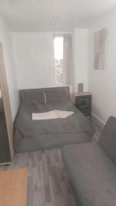 a living room with a couch and a window at Spacious Studio Maidstone - Redecorated Oct 2023 in Maidstone