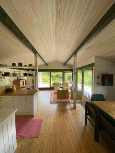 een grote keuken en een woonkamer met een groot plafond bij Holiday Home Holmehøj in Ebeltoft