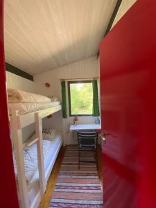 Cette petite chambre comprend des lits superposés et une fenêtre. dans l'établissement Holiday Home Holmehøj, à Ebeltoft