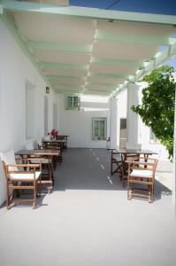 a row of tables and chairs in a white building at Georgias House in Skiros