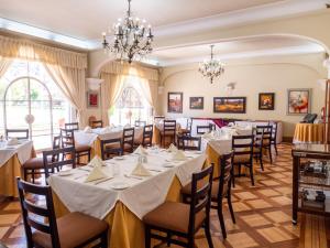 uma sala de jantar com mesas, cadeiras e lustres em LP Express Hotel Tarma em Tarma