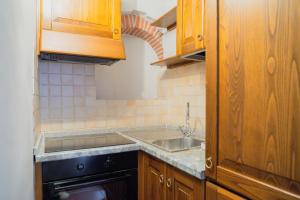 a kitchen with wooden cabinets and a sink at Torre al Serraglio in Prato