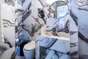 ein Badezimmer mit einem WC, einem Waschbecken und einem Spiegel in der Unterkunft Vassilia on the beach Serifos in Livadakia