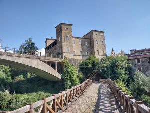 een brug over een pad voor een kasteel bij Castello di Pontebosio Luxury Resort in Licciana Nardi