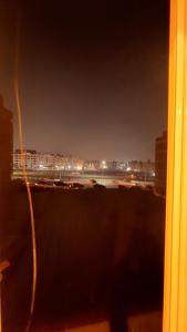een raam met uitzicht op de stad 's nachts bij Luxury Stay at Mokktam Heights in Caïro