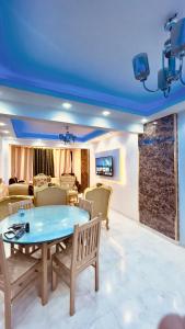 een woonkamer met een blauw plafond en een tafel en stoelen bij Luxury Stay at Mokktam Heights in Caïro