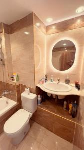 een badkamer met een toilet, een wastafel en een spiegel bij Luxury Stay at Mokktam Heights in Caïro