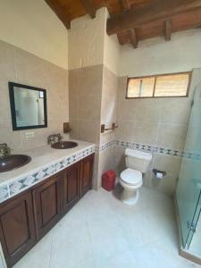 a bathroom with two sinks and a toilet at Hotel Campo Campestre La Coqueta in Santa Fe de Antioquia