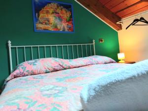 1 dormitorio con 1 cama y una pintura en la pared en La Locanda del Pettirosso en Agerola