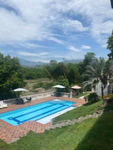 a large swimming pool in a yard next to a house at Hotel Campo Campestre La Coqueta in Santa Fe de Antioquia