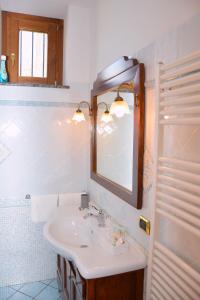 uma casa de banho com um lavatório e um espelho em La Locanda del Pettirosso em Agerola