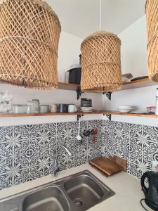a kitchen with a sink and baskets on the wall at Karoo Retreat- Self Catering Villas and Bed & Breakfast in Oudtshoorn