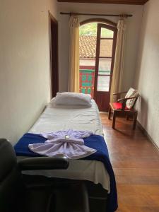 a bedroom with a bed with a dress on it at Casa do Alferes in Ouro Preto