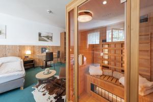 Zimmer mit einer Sauna, einem Bett und einem Schreibtisch in der Unterkunft AlpenParks Hotel MONTANA in Matrei in Osttirol