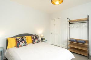 um quarto com uma cama branca e almofadas amarelas em Stratford House em Leicester