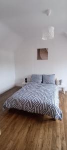 a bedroom with a bed with a black and white comforter at Maël-Carhaix location Maison 4 chambres in Maël-Carhaix