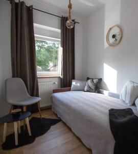 1 dormitorio con 1 cama, 1 silla y 1 ventana en Apartman Matea en Slavonski Brod