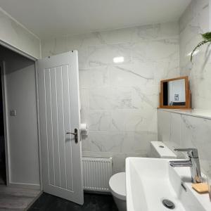La salle de bains blanche est pourvue de toilettes et d'un lavabo. dans l'établissement Bree and Geesi, à Birmingham