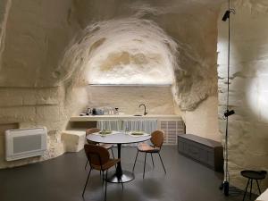 - une cuisine avec une table et des chaises dans une grotte dans l'établissement Marsili Suite, à Matera