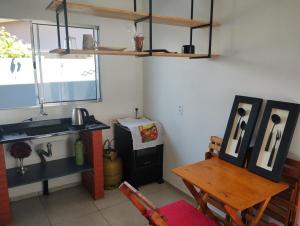 a kitchen with a sink and a table and a stove at Kitnet 4 in Cachoeira do Sul