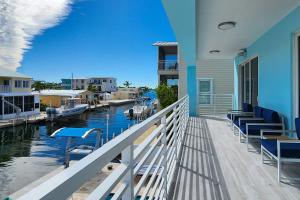 a balcony of a house with chairs and a marina at Afternoon Delight in Key Largo