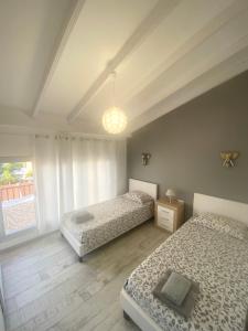 1 dormitorio con 2 camas y ventana en Ocean Park 7th floor sea and pool view, en Adeje