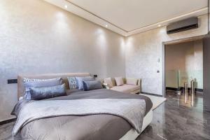 1 dormitorio con 1 cama grande y 1 silla en Splendide Villa Lilya, en Marrakech