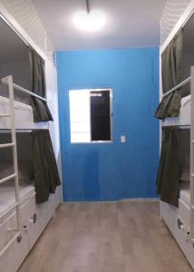 a room with two bunk beds and a blue wall at GVR Praia Hostel in João Pessoa