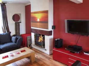 Il comprend un salon avec une cheminée et une télévision. dans l'établissement Tonga Cottage 302 Over Lane, à Belper