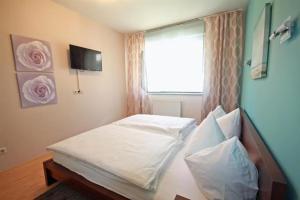 Schlafzimmer mit einem Bett mit einem Fenster und einem TV in der Unterkunft Apart 15 by Alpenidyll Apartments in Schladming