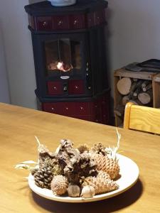 a plate of pine cones on a table with a fireplace at Casa con vista in Corniolo