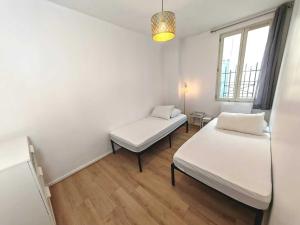 um pequeno quarto com 2 camas e uma janela em 3 Pièces à Saint-Ouen (Métro 13/14) em Saint-Ouen