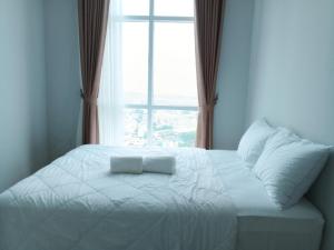 uma cama branca num quarto com uma janela em Formosa Spacious Apartments with Netflix & Free Shuttle by MESA em Nagoya