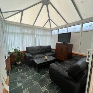 a living room with couches and a flat screen tv at Bree and Geesi in Birmingham