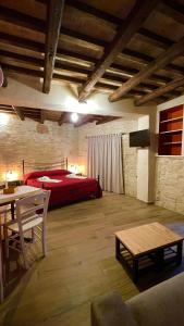 1 dormitorio con cama roja y mesa en Le Dimore dei Ritaldi, en Castel Ritaldi