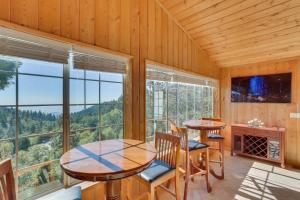 a dining room with two tables and a large window at Spacious Running Springs Home with Mountain Views in Running Springs