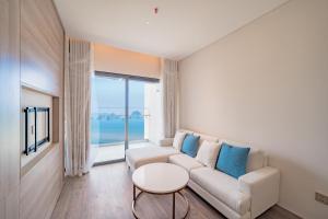a living room with a couch and a table at Căn hộ khách sạn Alacarte Hạ Long in Ha Long