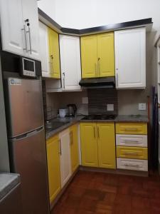 a kitchen with yellow and white cabinets and appliances at Manor Family in Durban