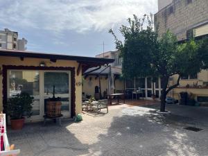 a building with a patio with a table and a tree at L'Approdo 2 in Casalnuovo di Napoli