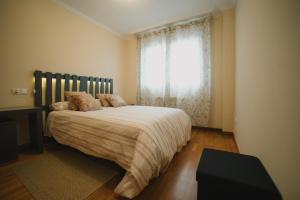 Un dormitorio con una cama grande y una ventana en Praza do Concello The Way en Negreira