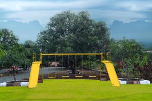 einen Spielplatz mit gelben Schaukeln in einem Park in der Unterkunft AamraKunj Gir Resort in Sasan Gir