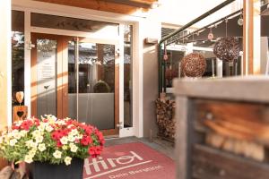 uma entrada para uma loja com flores na frente de uma porta em AlpenParks Hotel MONTANA em Matrei in Osttirol