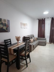 een woonkamer met een bank en een tafel en stoelen bij apartamento Castilla in Almodóvar del Río