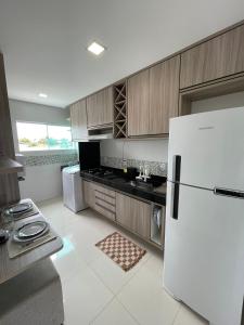 uma cozinha com um frigorífico branco e um fogão em Apartamento Aconchego Carapibus em Conde
