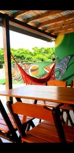 Praieira Hostel&Pousada في إيتاكاري: طاولة وكراسي خشبية مع لوحة على الحائط