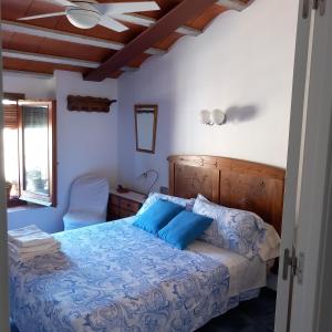 een slaapkamer met een blauw bed en een stoel bij Cal Manyo in Puigvert de Lérida