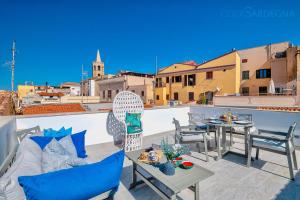 a patio with a table and chairs on a roof at ClickSardinia Alghero historic centre cosy penthouse with sea view terrace in Alghero