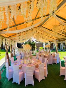 a marquee with tables and white chairs and chandeliers at Vila Forest Resort 