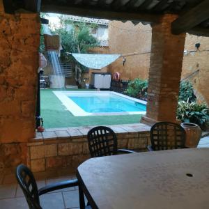 a patio with a table and a swimming pool at Caltarragona casa rural in Miralcamp